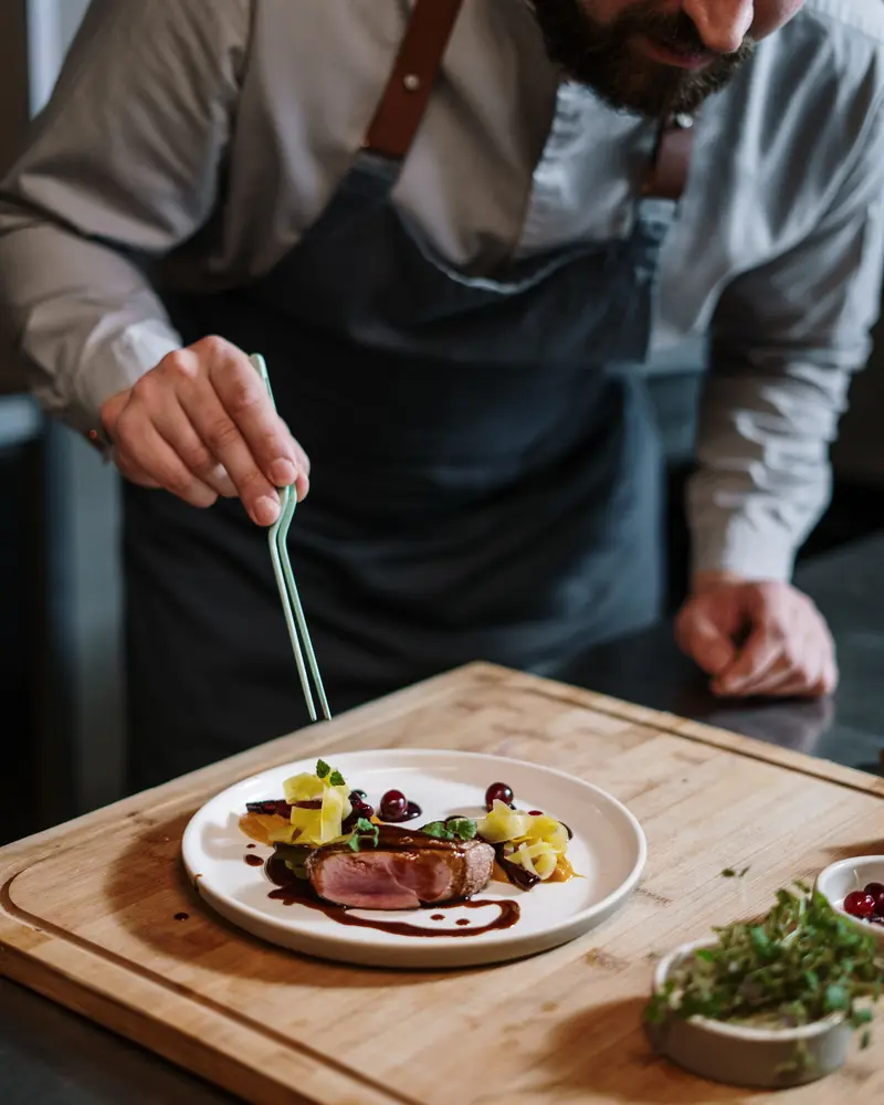 Cocinero emplatando en una cocina profesional